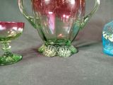 three different colored glass vases sitting next to each other