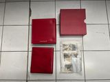 two red wallets and a red card case on a tiled floor