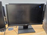 a computer monitor sitting on top of a wooden desk