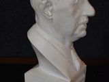 a white bust of a man on a black table