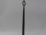 a black iron candle stand with a black candle on top