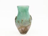 a green vase that is sitting on a white surface
