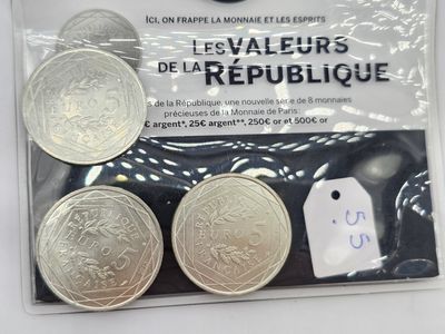 trois pièces d'argent dans un sachet en plastique muni d'une étiquette de prix
