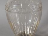 a glass vase with a silver lid sitting on a table