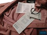 a brown jacket with a tag on it next to a passport and a ticket
