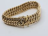 a gold bracelet on a white background