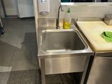 a stainless steel sink in the corner of a kitchen