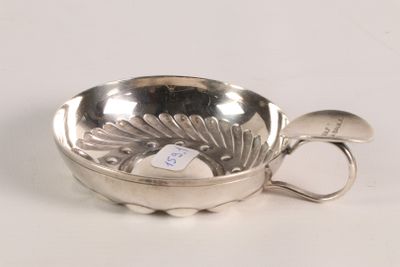 a silver bowl with a spoon in it on a white surface