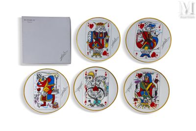 quatre assiettes sur lesquelles sont posées des cartes à jouer se trouvent à côté d'une boîte