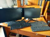 deux écrans d'ordinateur et un clavier sur un bureau