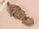 a silver pendant that has a small building on it