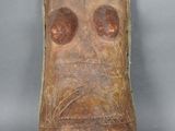 gros plan d'un masque en bois sur une surface grise