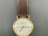 a close up of a wrist watch on a black surface