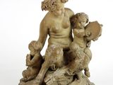 statue of a man and two children sitting on a rock