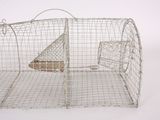 a metal cage with a mouse in it on a white surface