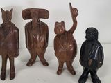 three wooden figurines of animals and a man in a tuxedo