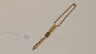 une image représentant un bracelet en or auquel est attachée une chaîne