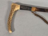 a wooden stick with a long handle on a white surface