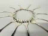 a lot of forks arranged in a circle on the table