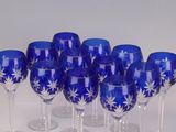 six blue wine glasses are lined up in a row on a white surface