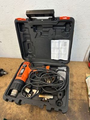 une perceuse électrique orange et noire dans un coffret posé sur une table