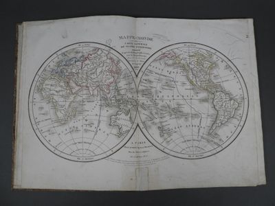 an old map of the world is open on a table