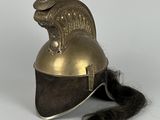 un gros plan d'un casque muni d'une longue queue, posé sur une surface blanche