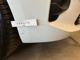 a close up of a white car with a measuring tape on it