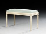 a white bench with a green cushion on top of it