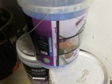 two buckets of paint sitting on the floor next to each other