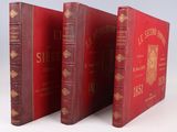 trois livres rouges sont alignés les uns à côté des autres sur une surface blanche