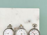trois horloges posées les unes à côté des autres sur un bloc de marbre