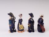 three figurines of people dressed in historical clothing and hats