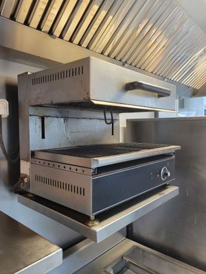 un four de cuisine dans une cuisine professionnelle équipée d'armoires en acier inoxydable