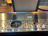 a stainless steel counter top with a sign on it