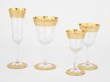 quatre verres à vin à bord doré et un verre à vin à bord doré