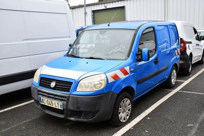 une camionnette bleue garée sur un parking à côté d'une camionnette blanche
