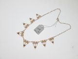a close up of a necklace on a white surface with a price tag
