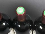 six bottles of wine are lined up in a row on a table