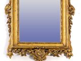 a gold frame with a mirror on it on a wall