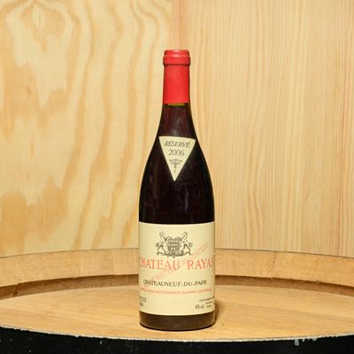 une bouteille de vin posée sur un tonneau en bois