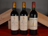 three bottles of red wine sit on a table next to a wooden box