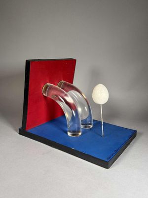un objet en verre contenant une balle de golf, posé sur un socle