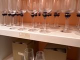 de nombreux verres à vin vides posés sur une étagère dans une pièce