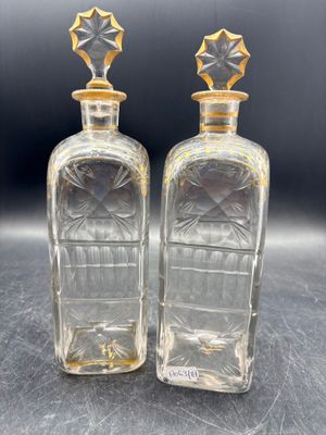 deux bouteilles en verre transparent ornées d'étoiles dorées sur le goulot