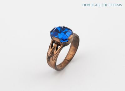 a close up of a ring with a blue stone on it