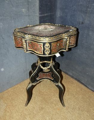 une petite table avec un plateau en marbre, placée dans un coin