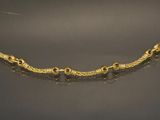 a close up of a gold bracelet on a black surface