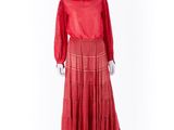 une robe rouge posée sur un présentoir à mannequin, sur fond blanc