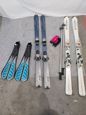 de nombreux skis et bâtons de ski disposés par terre